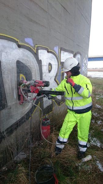 Pracownik robiący dziurę w ścianie